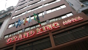 The exterior of the Grand King Hotel with its name illuminated in neon lights. - Grand King Hotel (Buenos Aires)