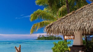 A beach hut with a thatched roof, a sign reading "BEACH HUT", and a chalkboard menu. - Pacific Resort Rarotonga (Rarotonga)