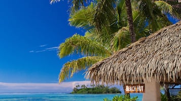 Pantai pribadi, pasir putih, kursi berjemur, dan handuk pantai