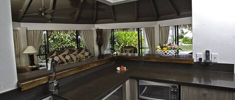 Una cocina moderna con horno empotrado, un fregadero y ventana con vistas a un jardín.