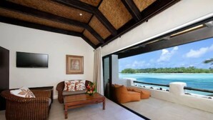 A modern living room with a large window overlooking a tropical beach. - Pacific Resort Rarotonga (Rarotonga)