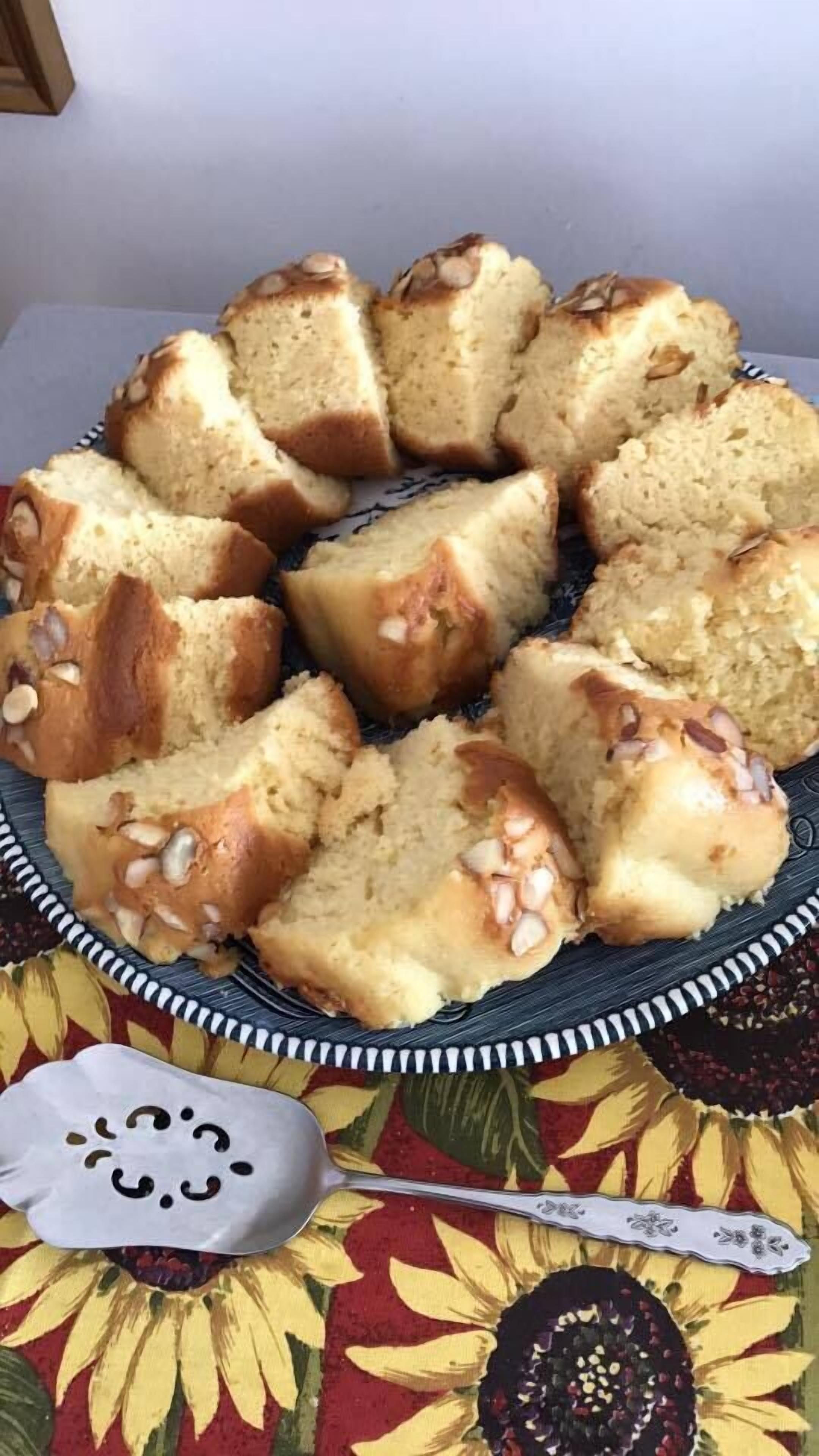 A plate of sliced bread with nuts on a tablecloth with a sunflower pattern.