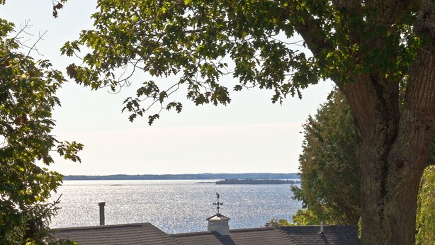 A view of a lake from a building with a tiled roof and a chimney. - Mount Battie Inn (Lincolnville)