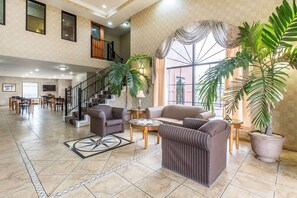 A spacious living area with a staircase, multiple seating options, and large windows. - Quality Inn Hanceville US Hwy 31 (Hanceville)