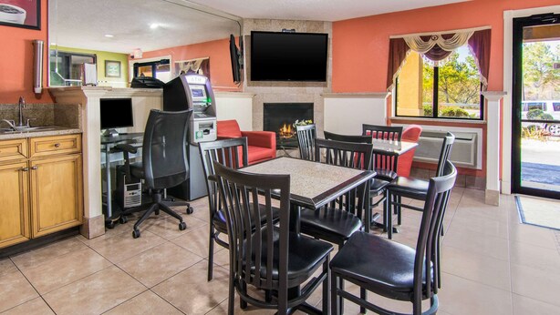 A restaurant with a fireplace, dining tables, chairs, a TV, and a counter with a cash register.
