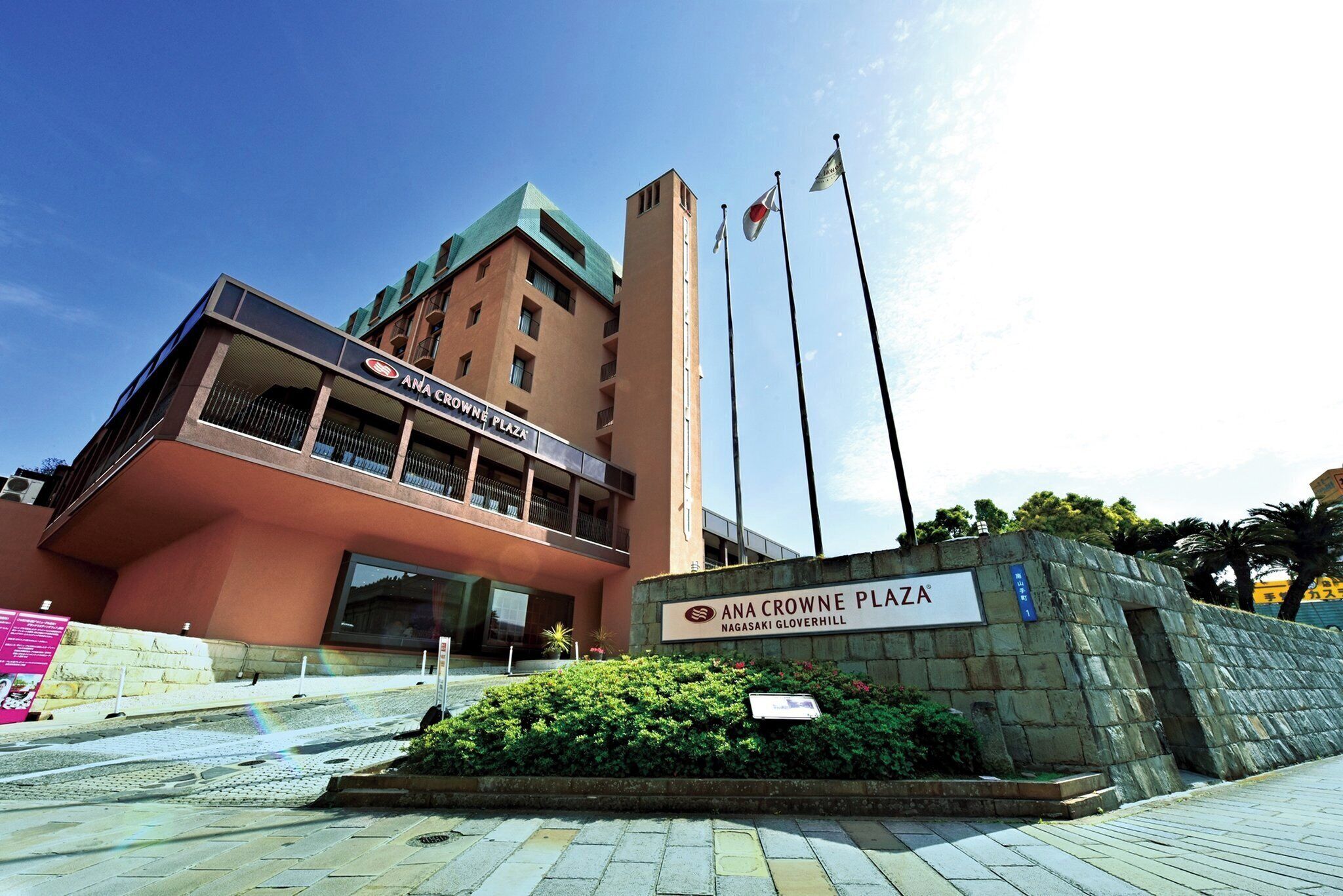 Un edificio con un cartello che riporta la scritta 'ANA CROWNE PLAZA NAGASAKI GLOVERHILL'.
