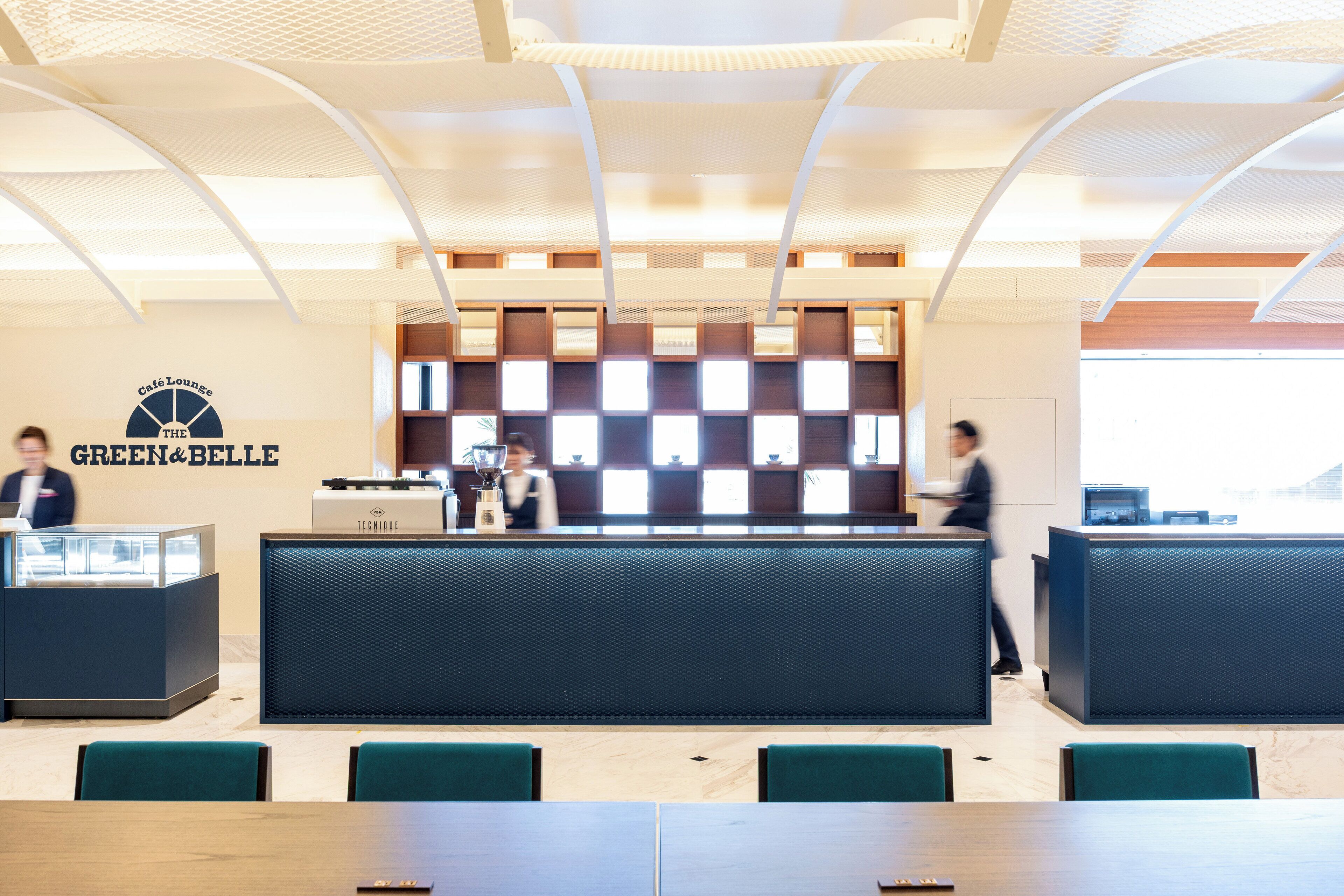 A cafe lounge with a reception desk, seating area, and a large window.