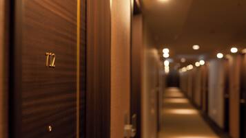 A hotel hallway with doors marked with room numbers, leading to individual rooms.