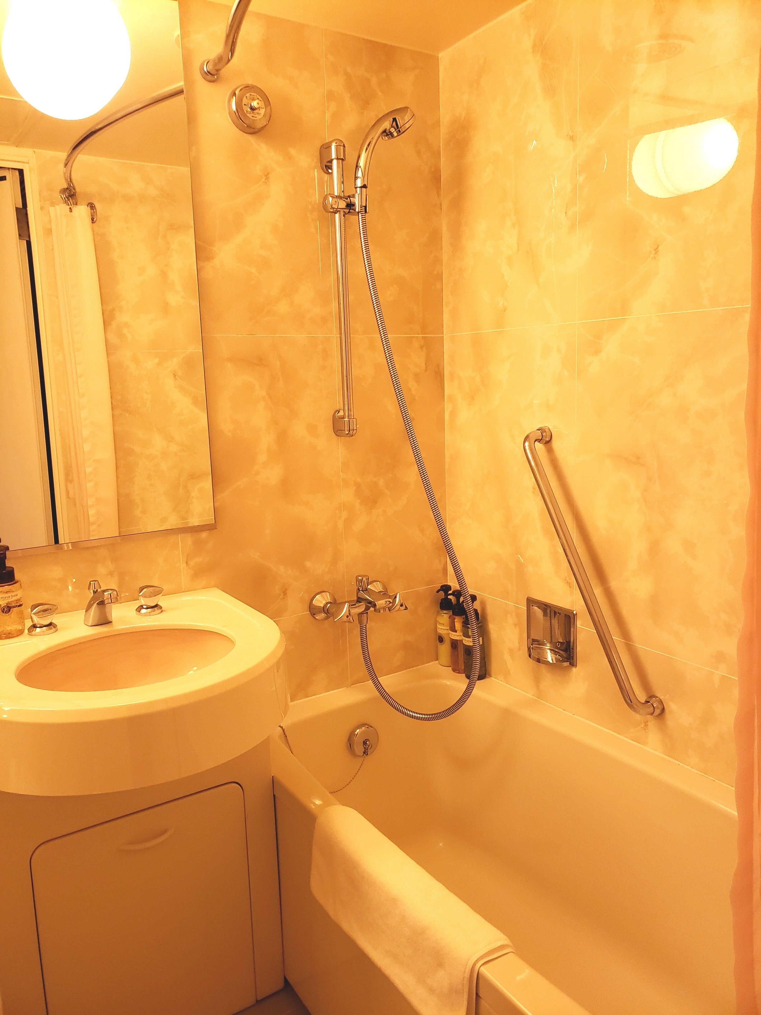 Un baño con lavamanos, espejo y bañera.