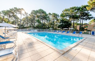 Una piscina al aire libre, sillones reclinables de piscina