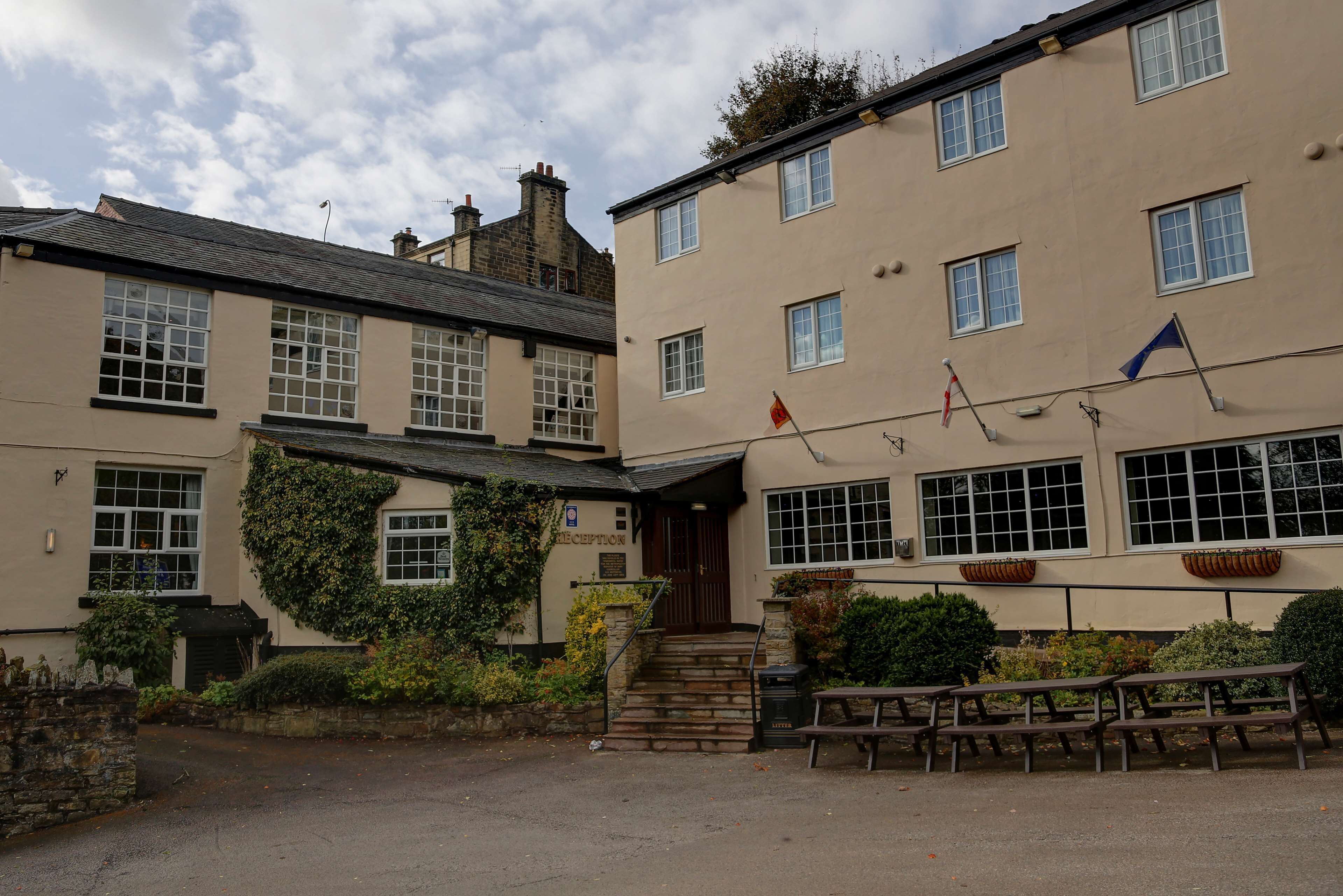 A building with a reception area, stone steps, and outdoor seating.