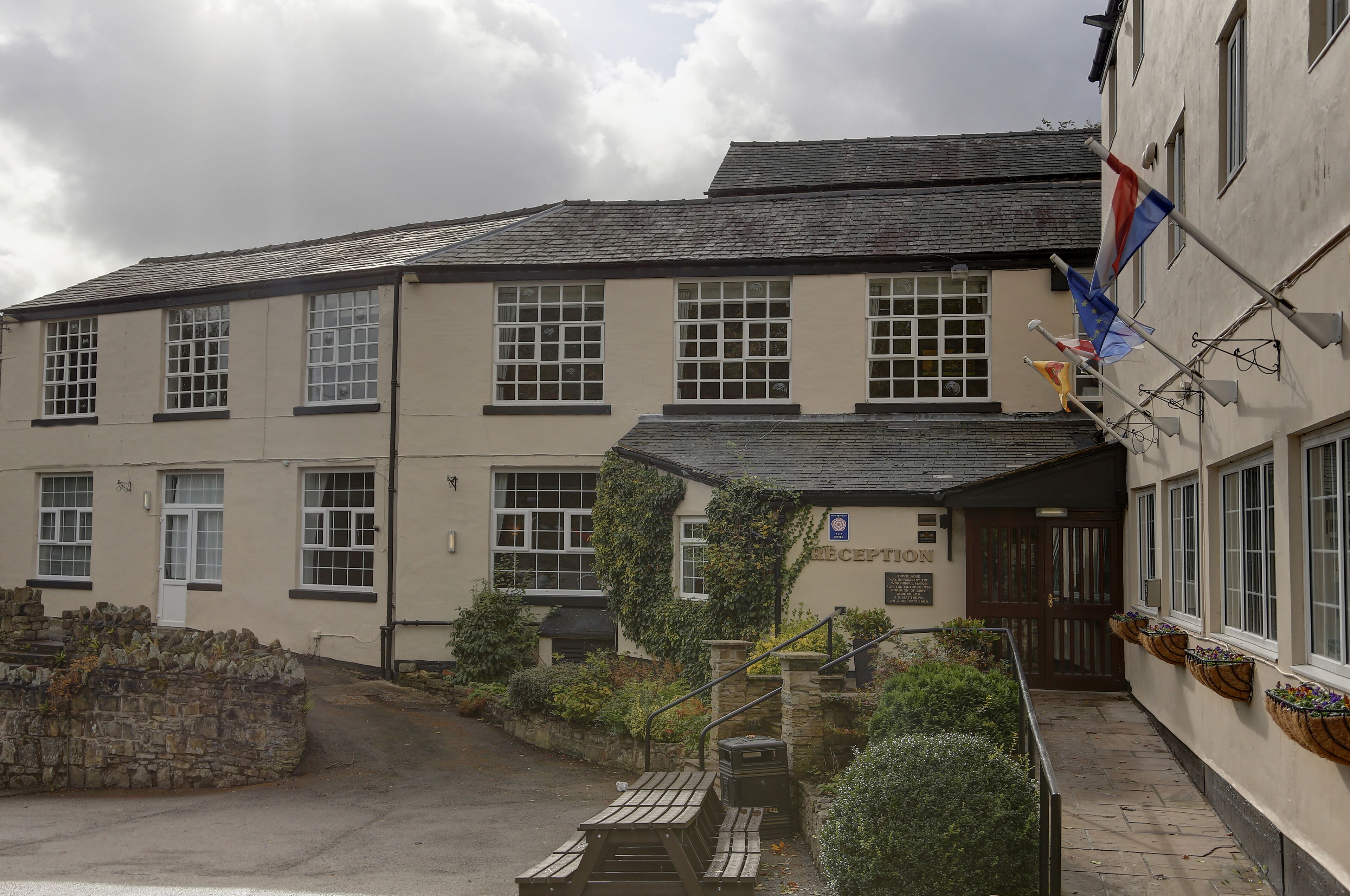 A building with a reception area, stone steps, and flags.