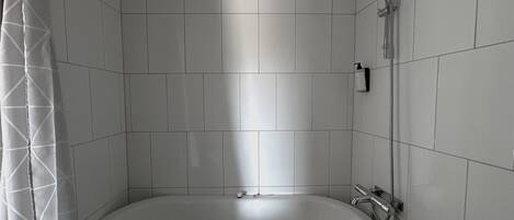 Un baño con bañera, ducha e inodoro.