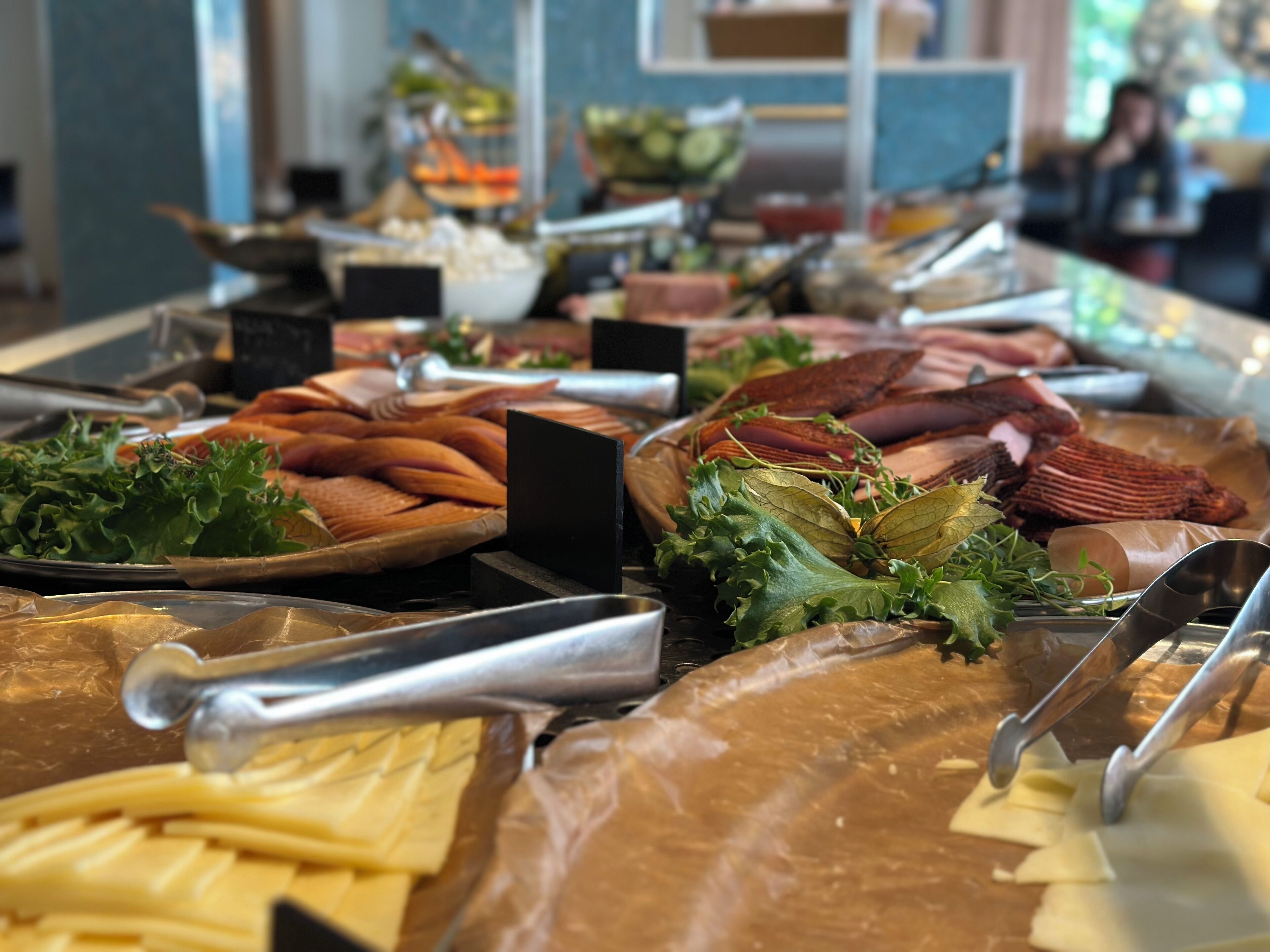 En buffet med forskelligt kød, oste og grøntsager.