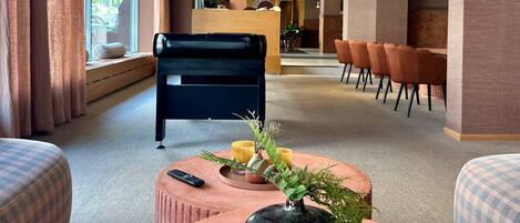 Un moderno vestíbulo de hotel con una gran mesa redonda, zona de estar y mostrador de recepción.