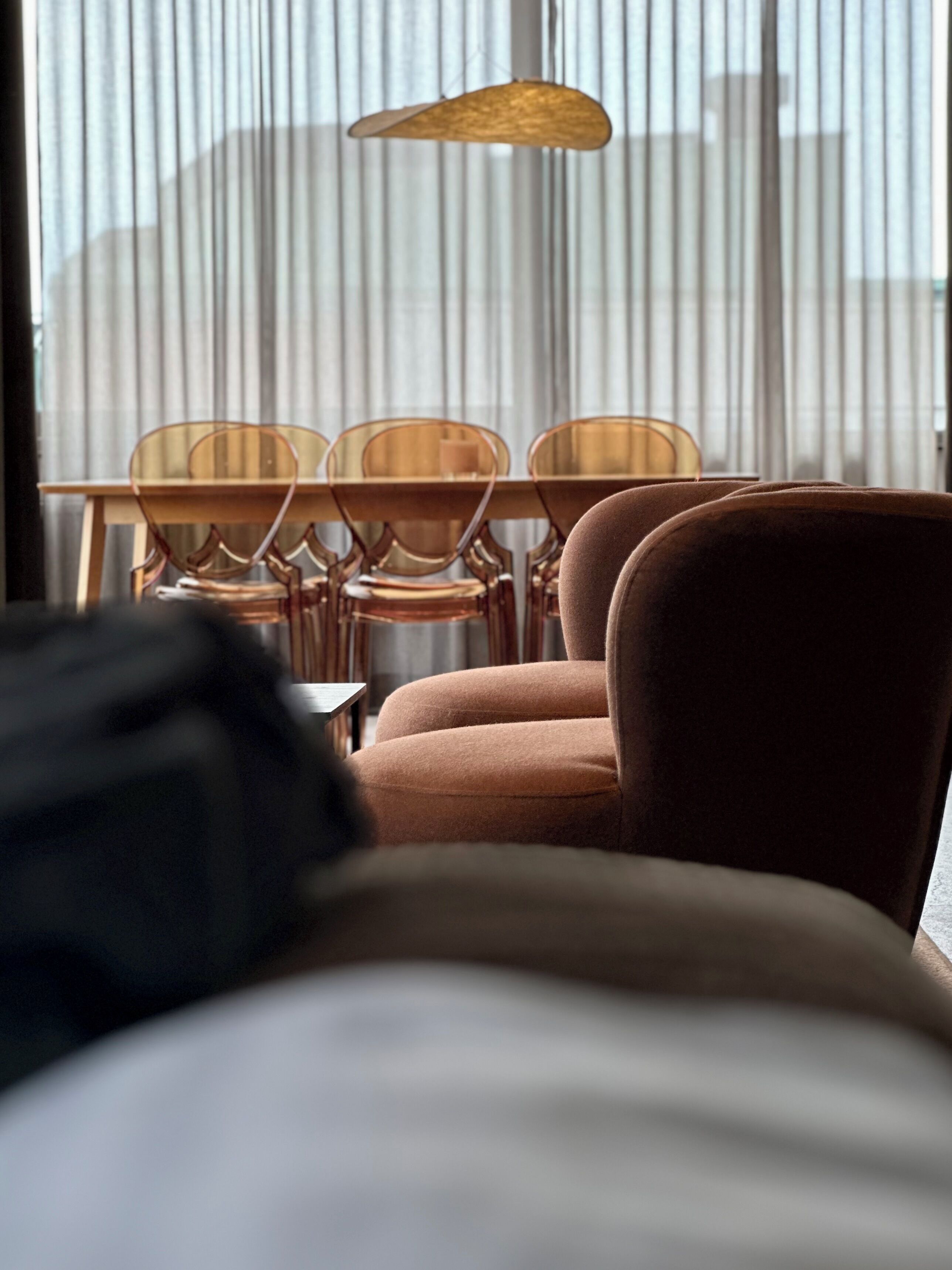 Una habitación con cama, una mesa con sillas y una ventana con persianas.