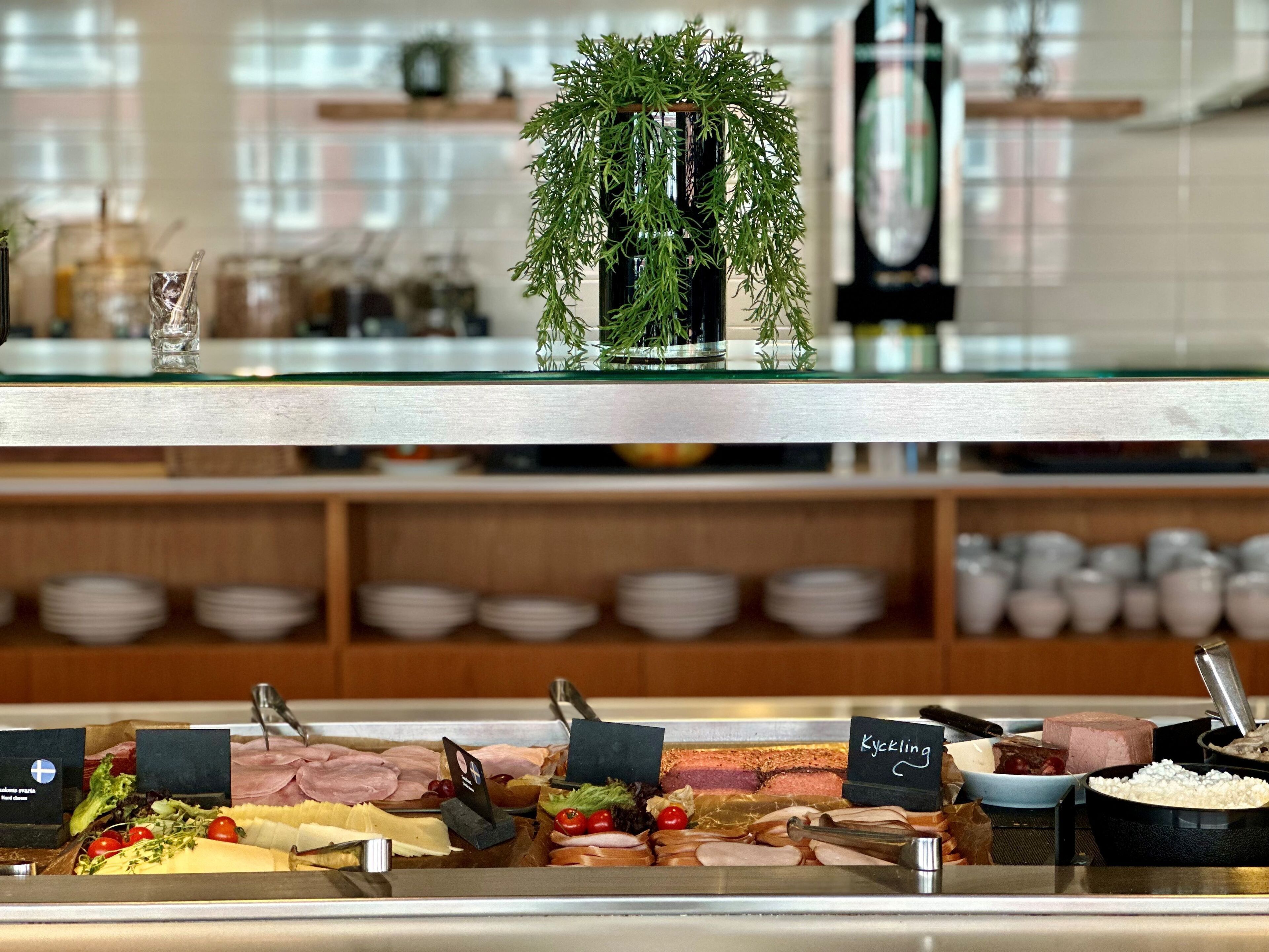 A buffet with various food items and a decorative plant on the counter.