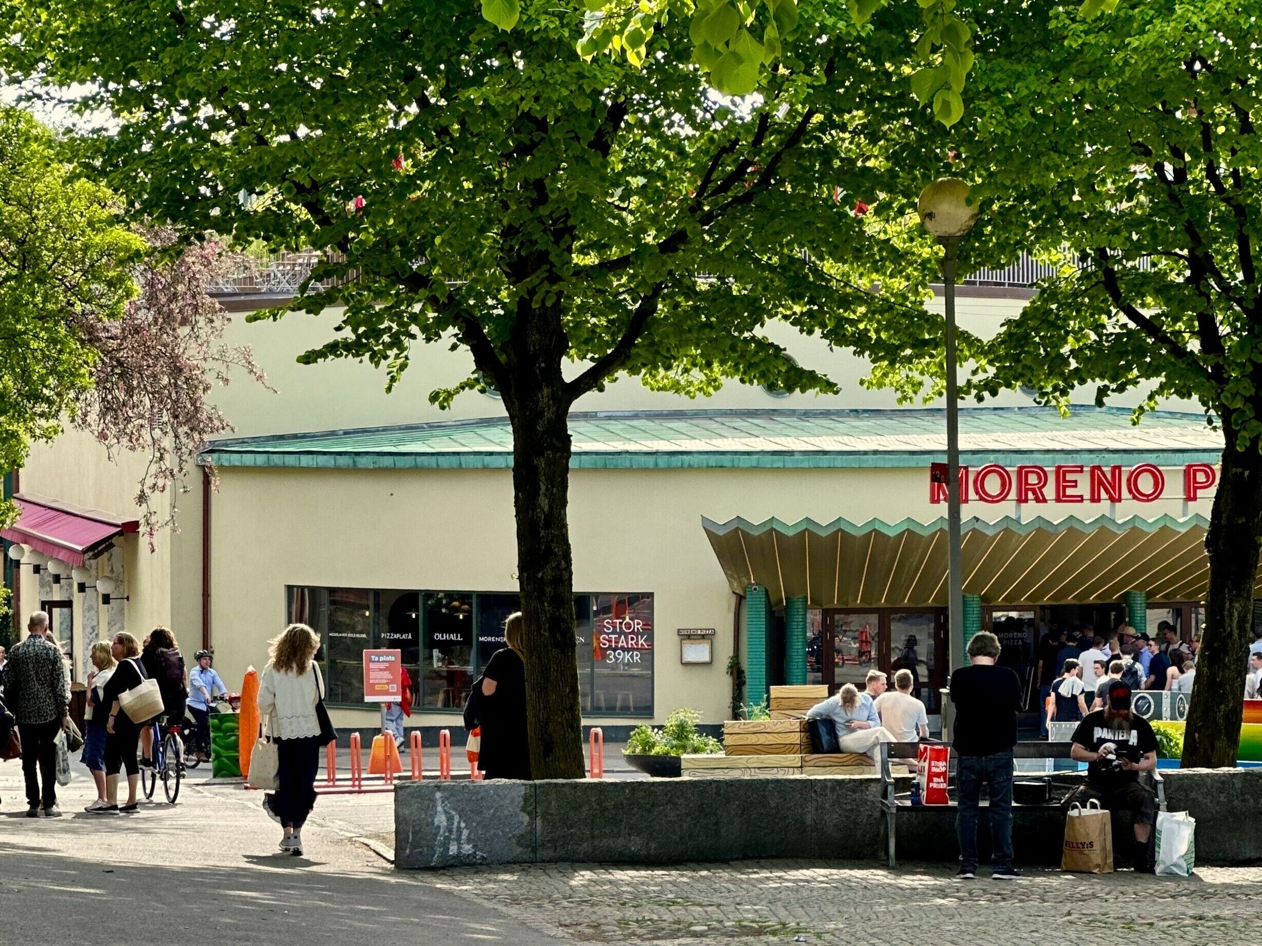 A street scene with a building labeled 'MORENO PIZZA' and a pedestrian walkway.