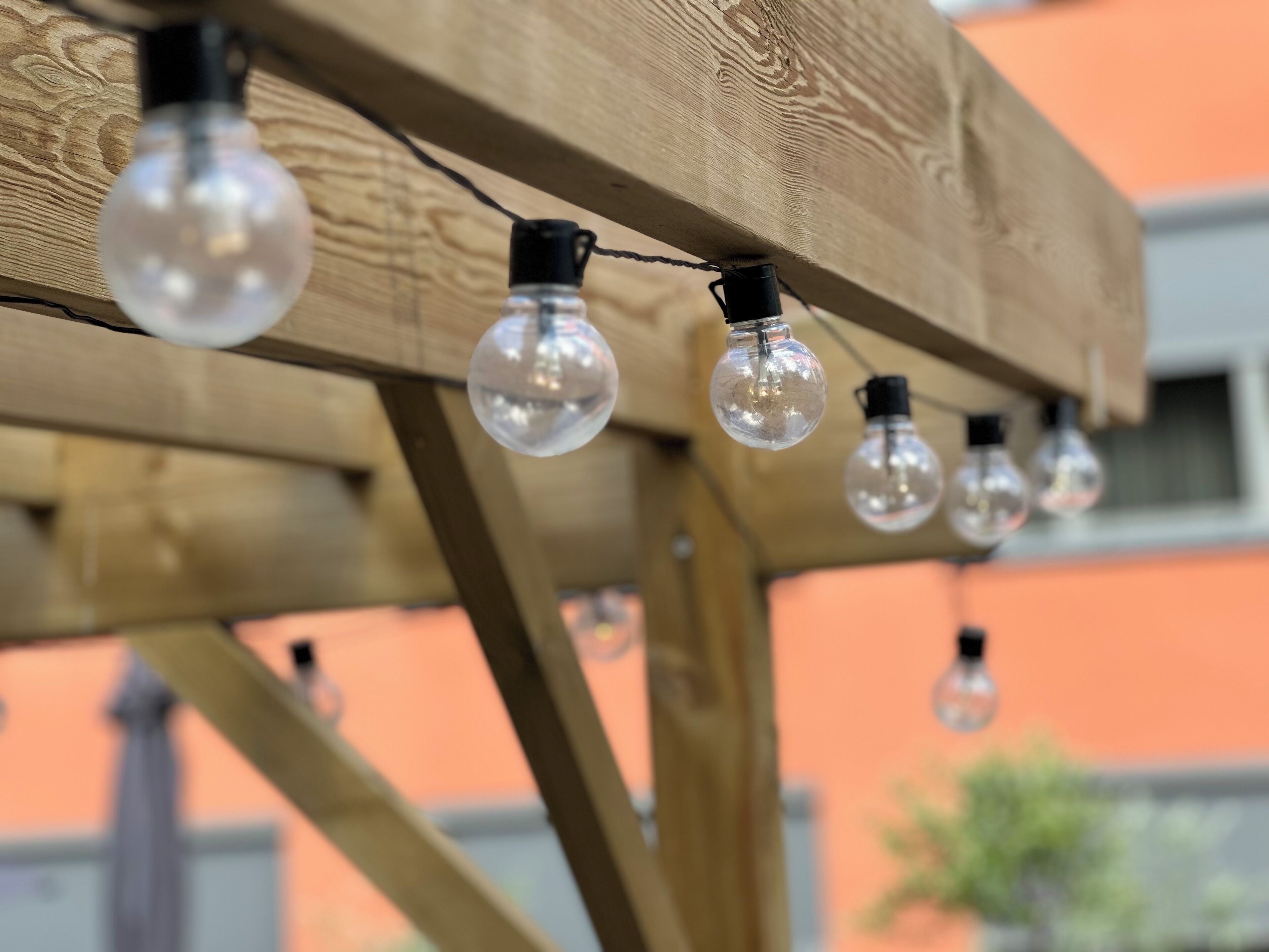 A wooden structure with multiple clear glass bulbs hanging from it.