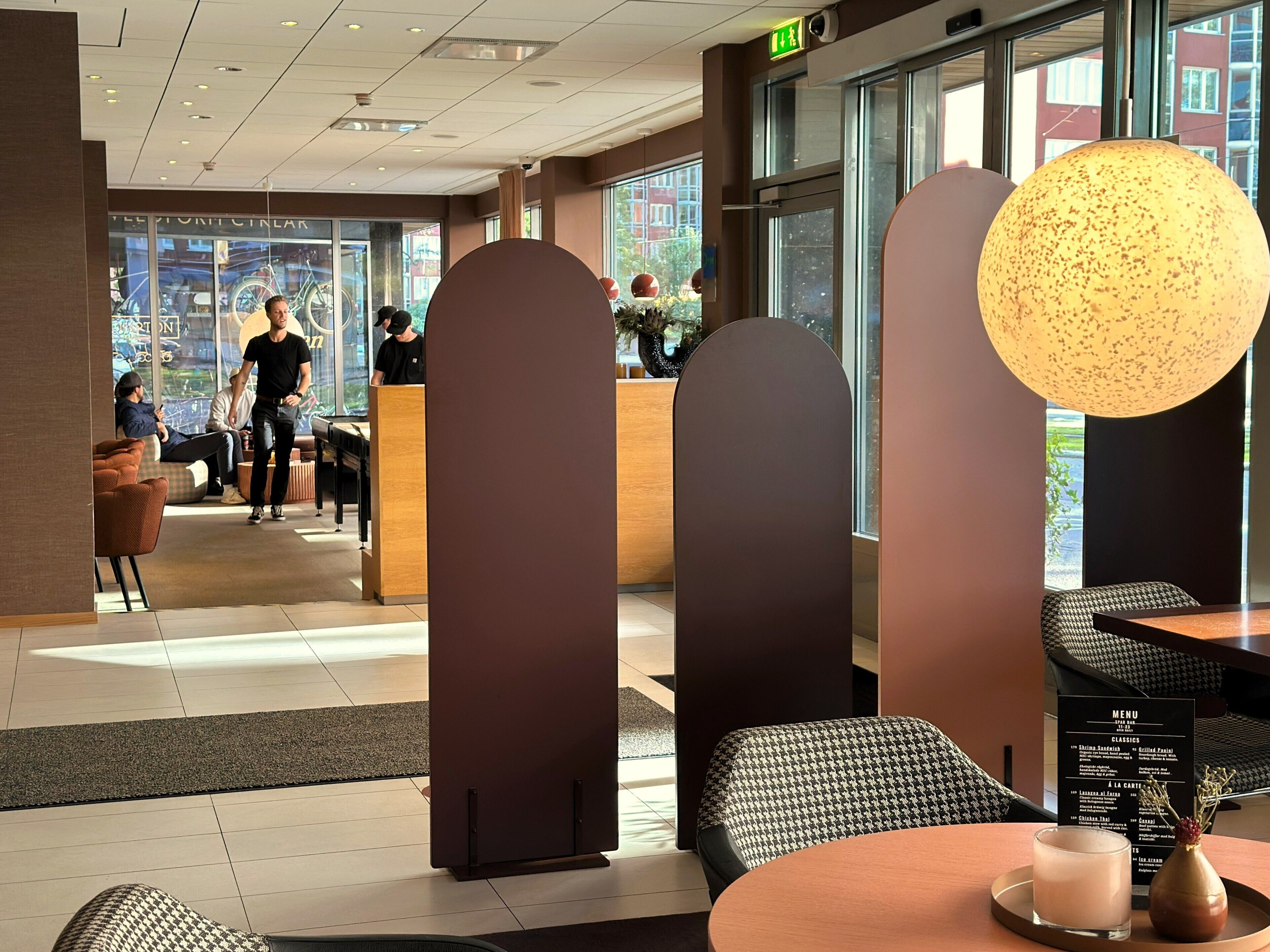 A modern interior with a reception desk, seating area, and a menu board.