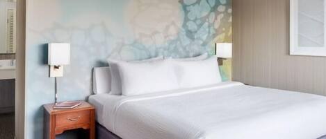 A hotel room with a bed, nightstand, and a wall with a textured design.