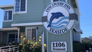 A sign for Discovery Inn Seaside with a dolphin logo, located at 1106 Fremont. - Discovery Inn (Seaside)