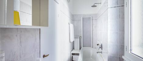 A bathroom with a bathtub, a shower, a toilet, and a sink.