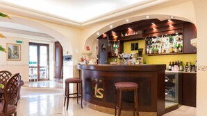 A bar area with a counter, stools, and a display of bottles. - Hotel Stella Rapallo (Rapallo)