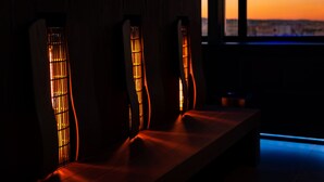 A dimly lit room with a bench and three vertical light fixtures.