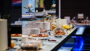 A buffet with various food items and a piano in the background.