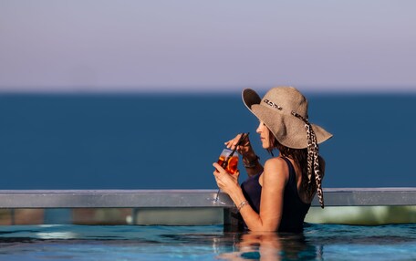 Una persona en una piscina con vista al océano.