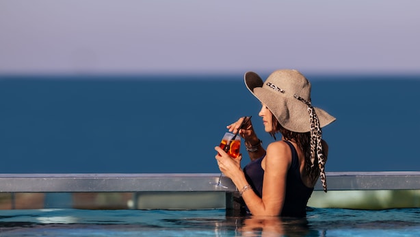 A person in a swimming pool with a view of the ocean.