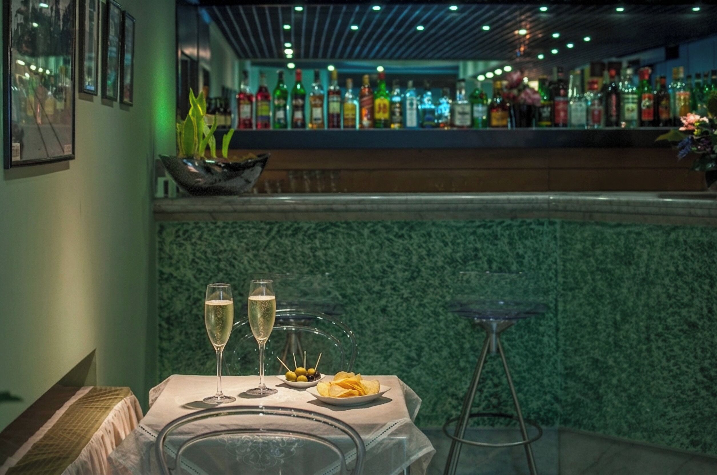 Un espace bar avec des bouteilles et un mur végétal.