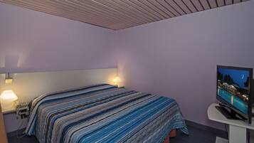 Ein Hotelzimmer mit einem Bett, einem Fernseher und einem Nachttisch.