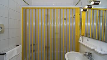 Ein Badezimmer mit Duschkabine, Waschbecken und Spiegel.