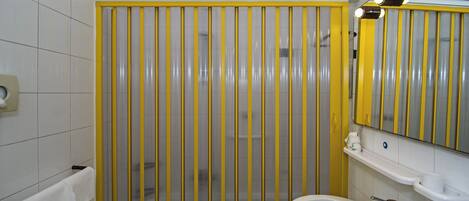 Un baño con cabina de ducha, lavamanos y espejo.