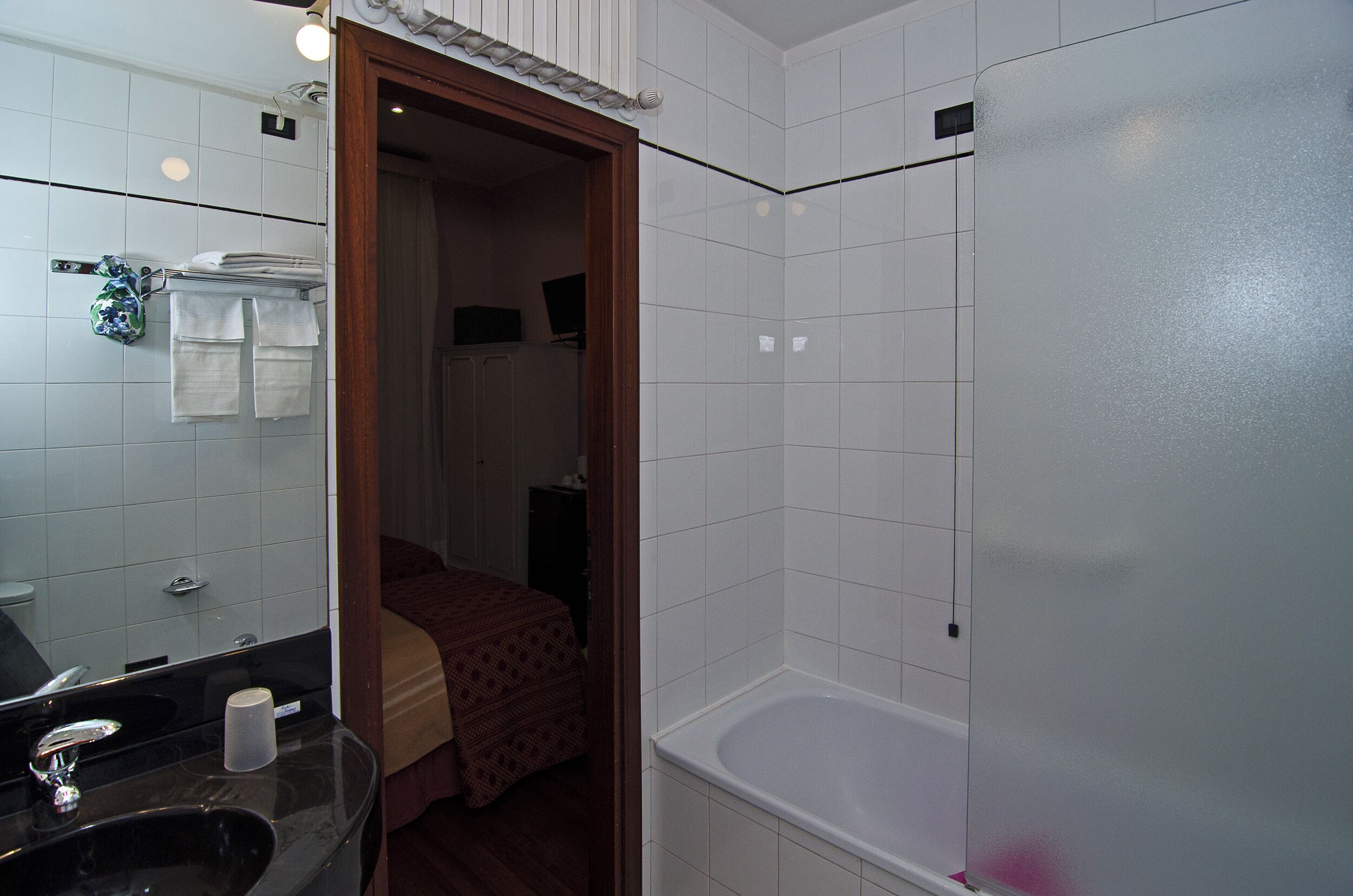 Een badkamer met een bad, een wastafel en een spiegel.