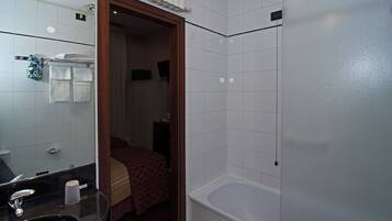 Een badkamer met een bad, een wastafel en een spiegel.
