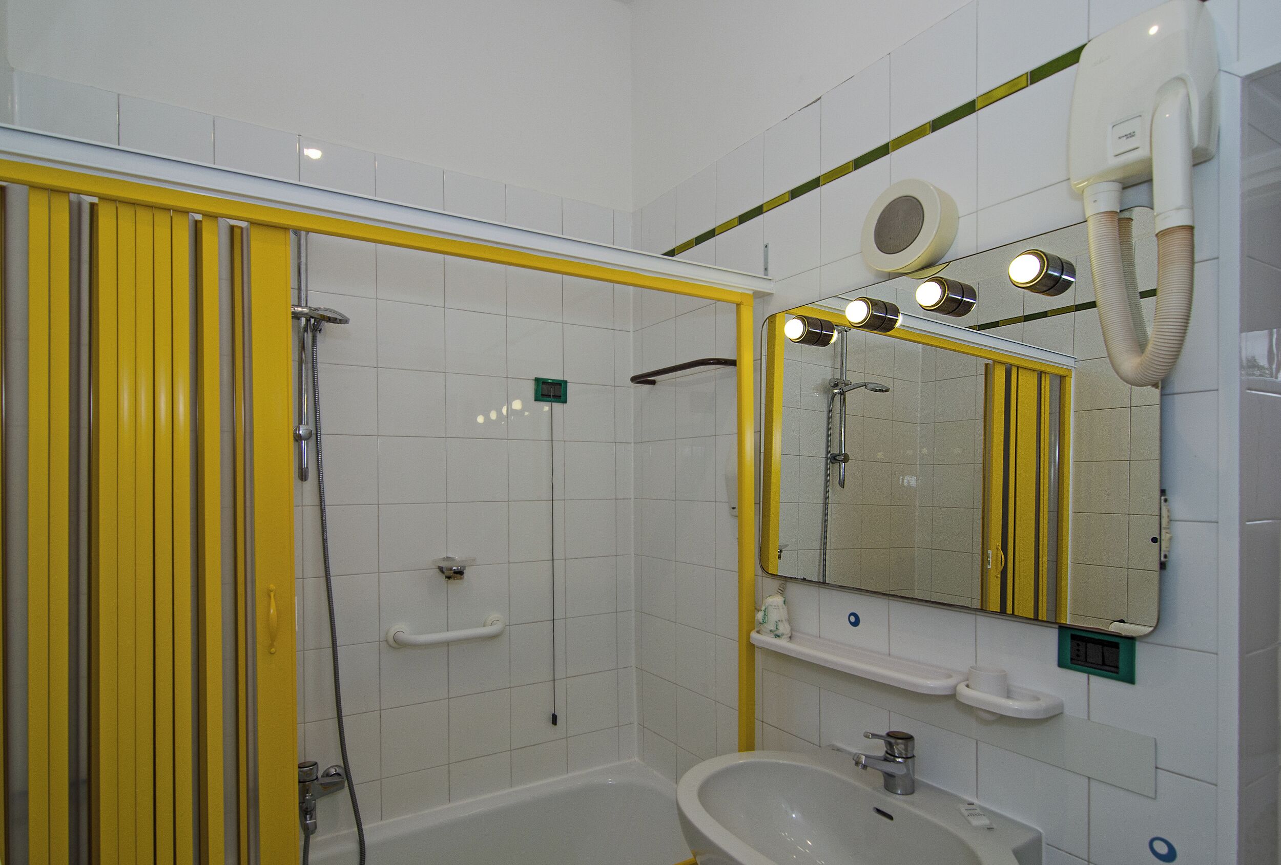 A bathroom with a bathtub, a sink, and a mirror.