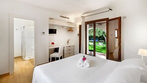 Une chambre d’hôtel avec un lit, un bureau, une chaise et une vue sur un jardin.