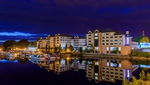 A waterfront hotel with multiple buildings, a marina with boats, and a reflection in the water. - Radisson Blu Hotel, Athlone (Athlone)