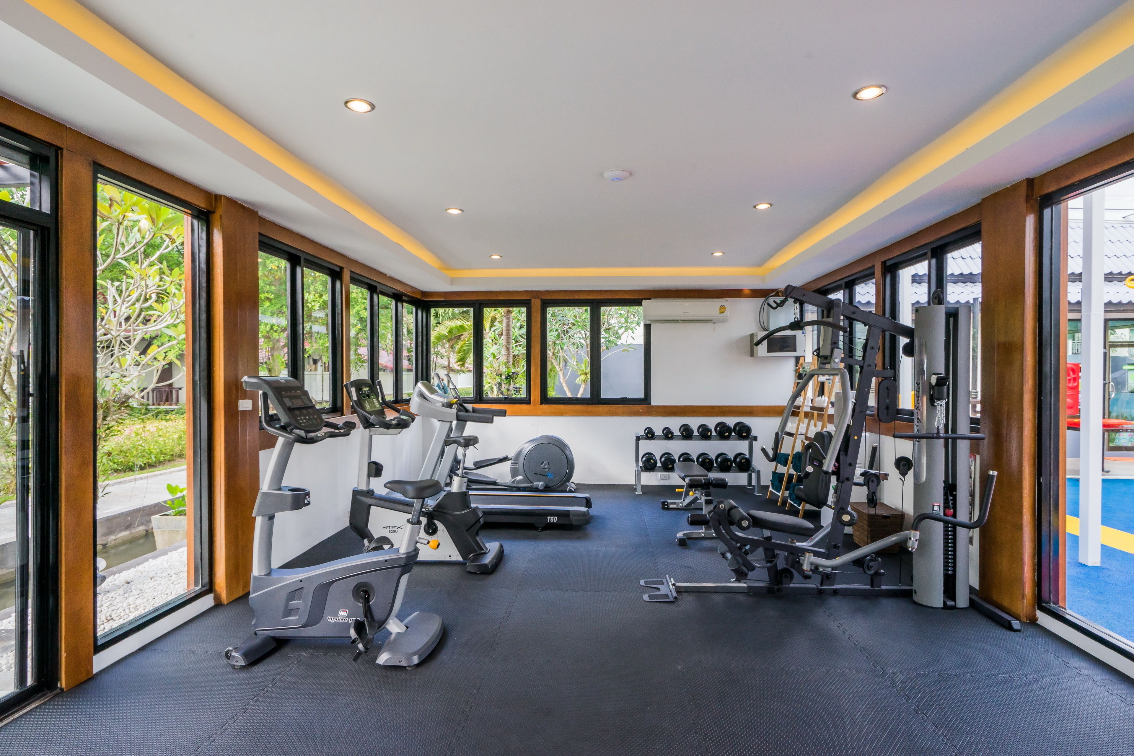 A gym with treadmills, dumbbells, and weight machines.