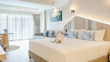 Habitación de hotel moderna con una cama grande, un sofá, una mesa de comedor y vistas al exterior.