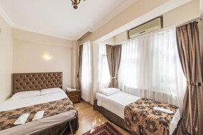 Habitación triple | Minibar, caja de seguridad en la habitación, wifi gratis y ropa de cama 