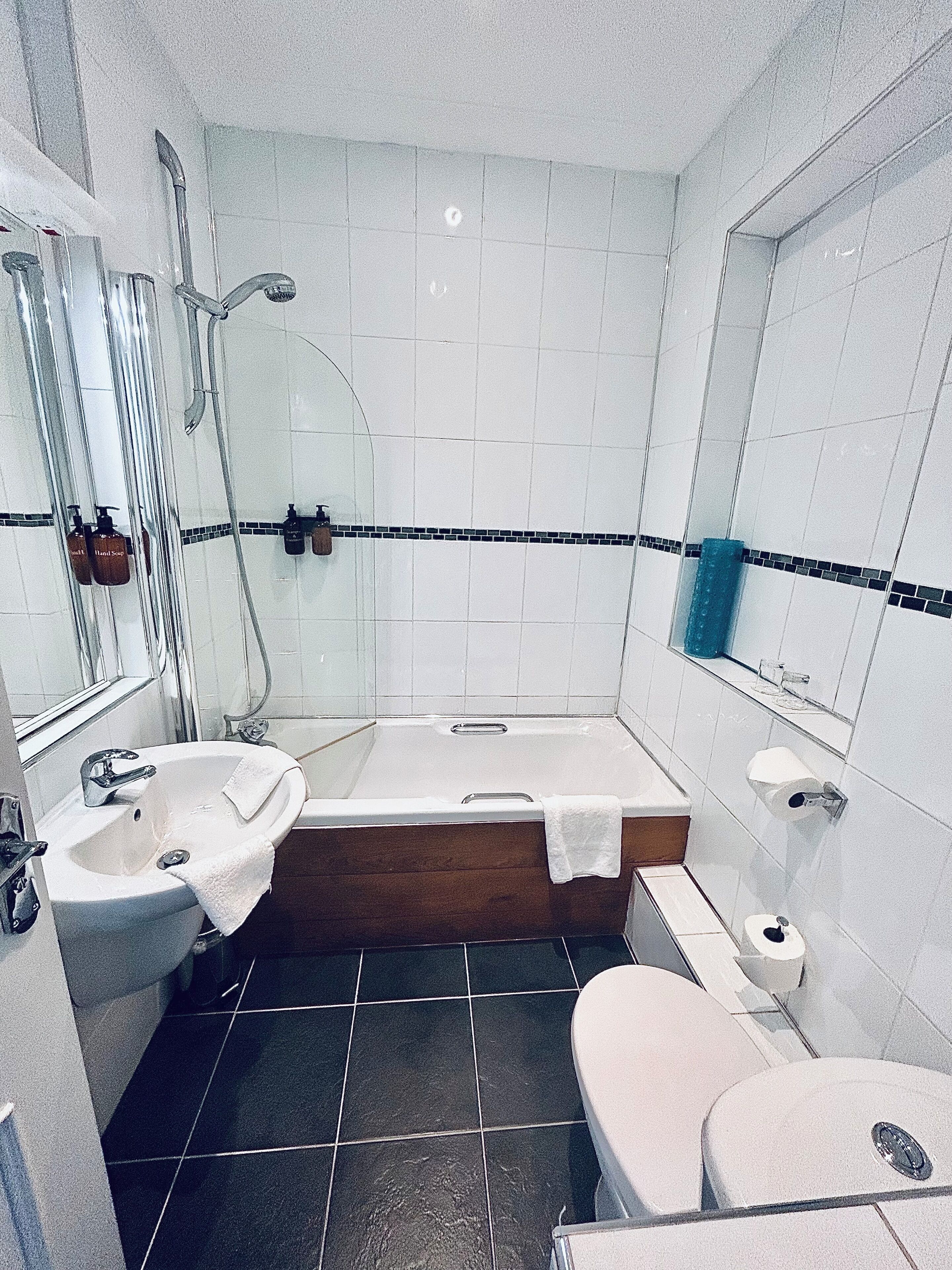 Un baño con bañera, lavamanos e inodoro.