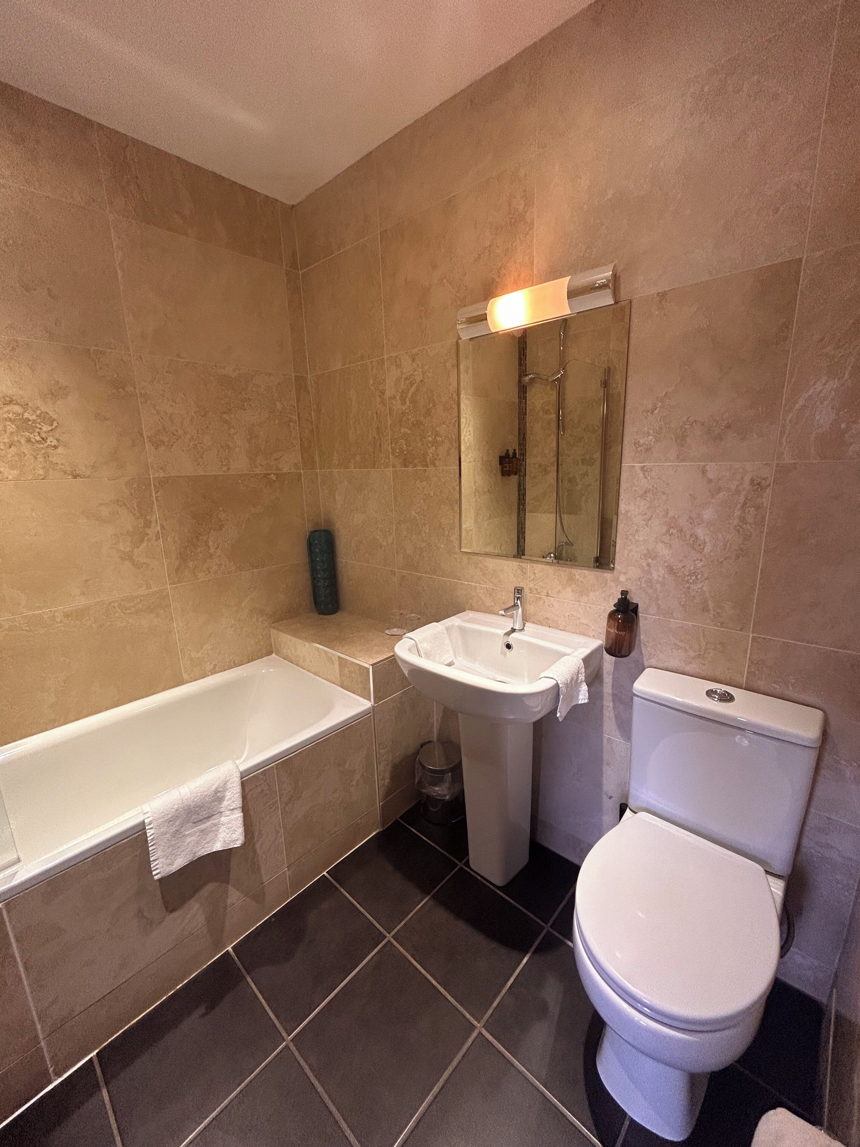 A bathroom with a bathtub, sink, and toilet.