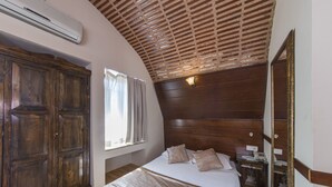 A bedroom with a wooden headboard, a large wardrobe, a bedside table with a lamp, and a window with curtains. - Naz Wooden House Inn - Byzantine House (Istanbul)