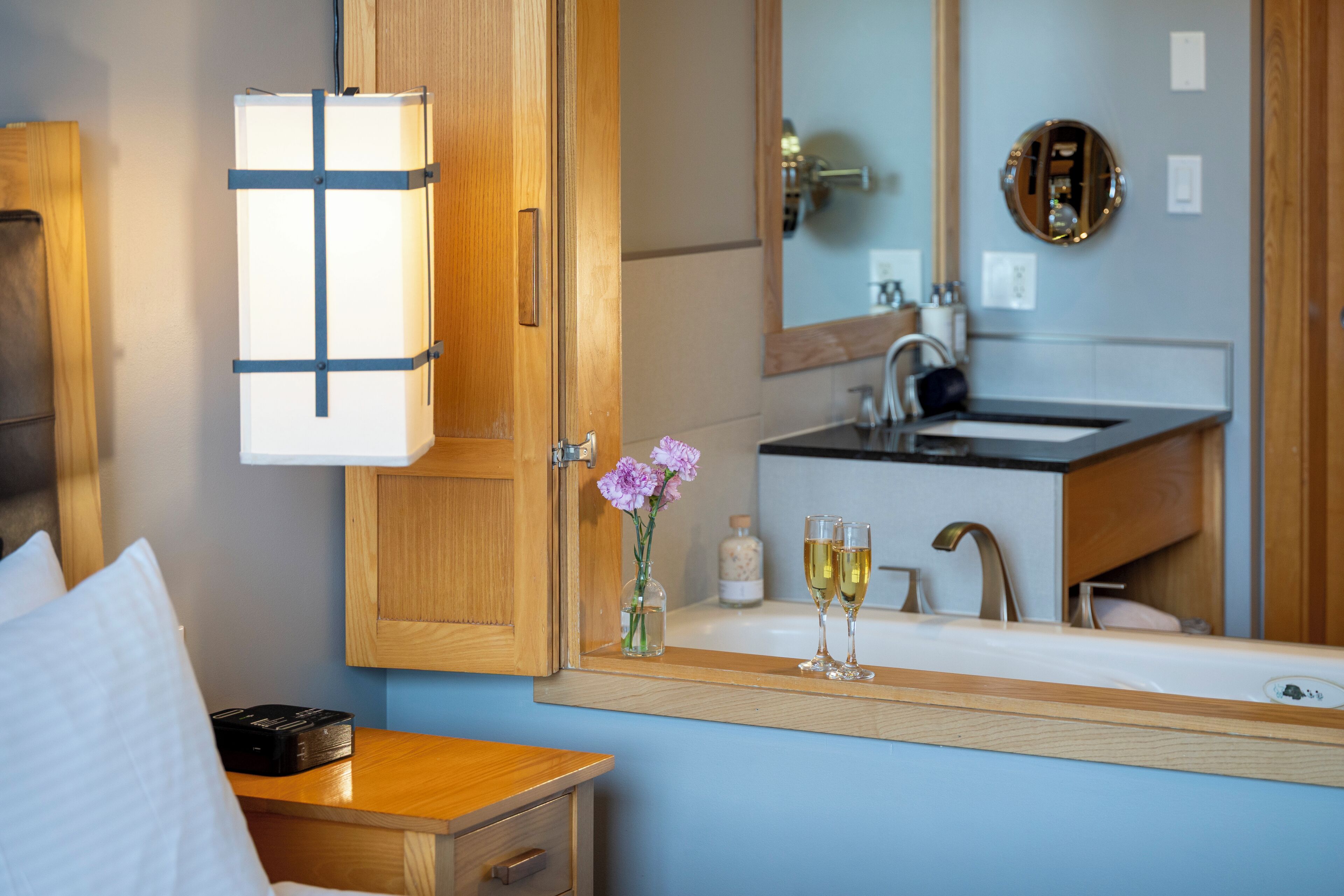 Une salle de bain d’hôtel avec des meubles en bois, un lavabo et un miroir.