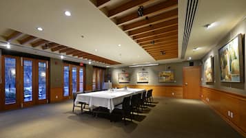 A conference room with a long table, chairs, and artwork on the walls.