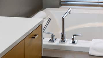 Un baño moderno con una bañera blanca, grifería cromada y muebles de madera.